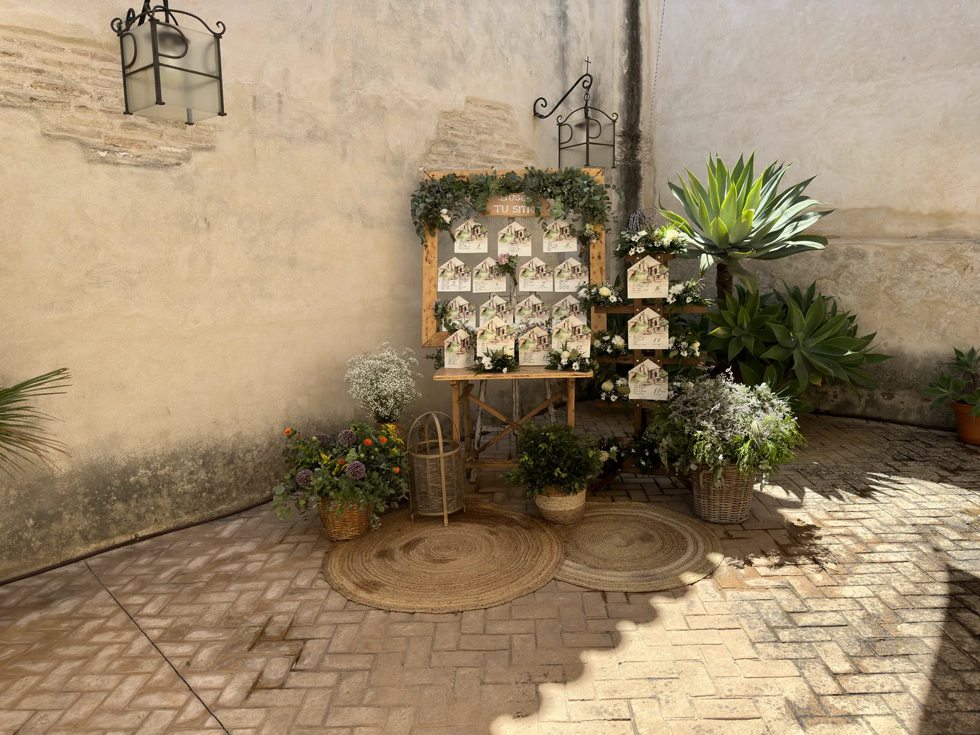 Rincón de bienvenida para invitados decorado con plantas y recuerdos